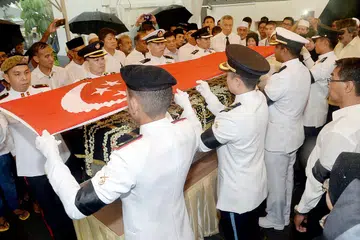 PENGHORMATAN TERTINGGI: Keranda jenazah Allahyarham Othman Wok diselimuti bendera negara sebelum diusung ke pedati meriam oleh Rombongan Penjunjung Keranda di Masjid Sultan semalam. - Foto JOHARI RAHMAT
