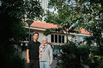 SELESA SUASANA 'KAMPUNG': Pasangan suami isteri Cik Fildza Zin dan Encik Juherman Zaiton sanggup membayar harga tinggi bagi teres HDB kerana impikan suasana kampung yang lebih santai dan peluang berkebun serta menternak ayam. Gambar kecil kanan menunjukkan Cik Fildza sedang bercucuk tanam di luar rumahnya. - Foto BM oleh HARITH MUSTAFFA
