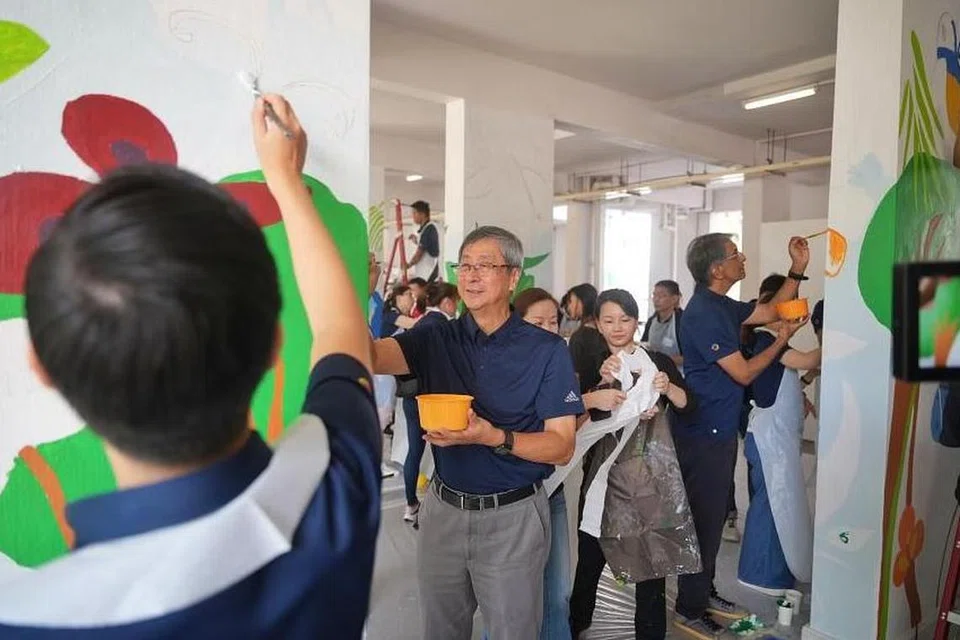Pengerusi syarikat pelaburan pemerintah, Temasek Holdings, Encik Lim Boon Heng (dua dari kiri) dan Ketua Pegawai Eksekutif (CEO) Temasek, Encik Dilhan Pillay (kanan) melukis mural di sebuah kolong blok semasa Hari Komuniti tahunan syarikat itu pada 25 Jun.