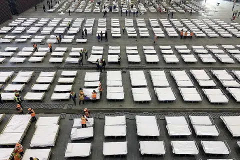 SEMUA KAUM BOLEH KENA WABAK: Pekerja menguruskan katil di hospital mudah alih yang didirikan di sebuah pusat pameran di Wuhan, ibu kota wilayah Hubei di China, tempat koronavirus Covid-19 kali pertama dikenal pasti. Wabak ialah bencana yang boleh melanda semua kaum, yang pada sama merupakan peluang bagi manusia belajar bersabar. - Foto EPA-EFE