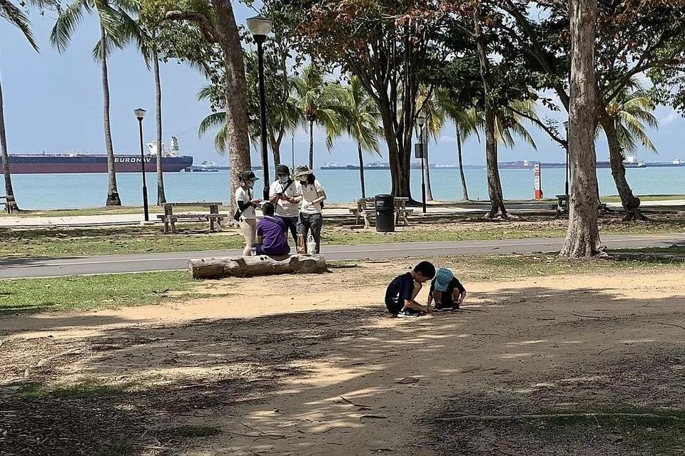 JALANKAN TUGAS: Tiga pegawai penguatkuasaan dilihat menghampiri seorang lelaki yang sedang duduk berseorangan di Taman East Coast pagi tadi. Mereka yang didapati bersalah tidak mematuhi langkah jarak selamat dan berlengah-lengah tanpa sebab akan terus dikenakan denda saman $300.