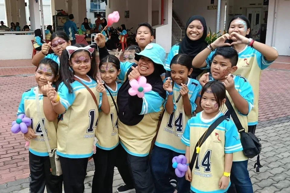 Cik Sarimah Amat (barisan hadapan, tiga dari kanan) bersama kanak-kanak di bawah program ‘Champs’, sebuah inisiatif bimbingan dan sokongan masyarakat yang diasaskannya untuk membantu golongan kanak-kanak daripada keluarga memerlukan.