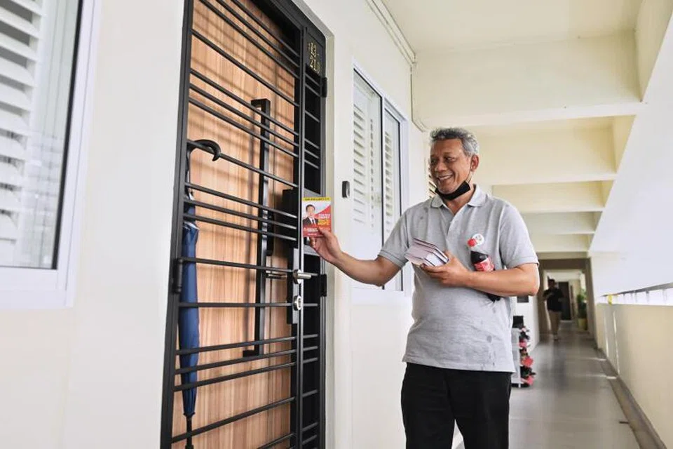 EDAR RISALAH: Sukarelawan pasukan kempen calon Presiden, Encik Tan Kin Lian, melawat rumah ke rumah dan mengedarkan risalah di 181 Stirling Road.