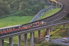 Kakitangan SMRT memeriksa gerabak kereta api yang terjejas di luar Depot Ulu Pandan kira-kira 1.45 petang pada 26 September. 