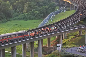 Kakitangan SMRT memeriksa gerabak kereta api yang terjejas di luar Depot Ulu Pandan kira-kira 1.45 petang pada 26 September. 