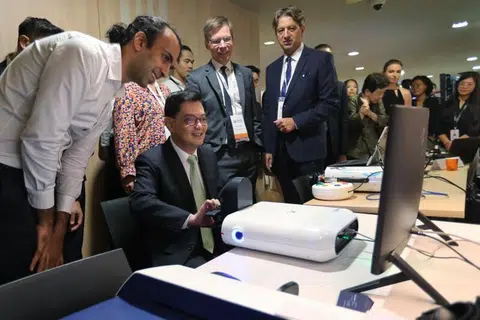 MANFAAT PERKONGSIAN: Encik Heng Swee Keat (dua dari kiri) di Simposium CREATE pada Isnin mencuba teknologi baru yang dihasilkan Universiti ETH Zurich dan dikomersialkan oleh Articares, sebuah syarikat alat perubatan.