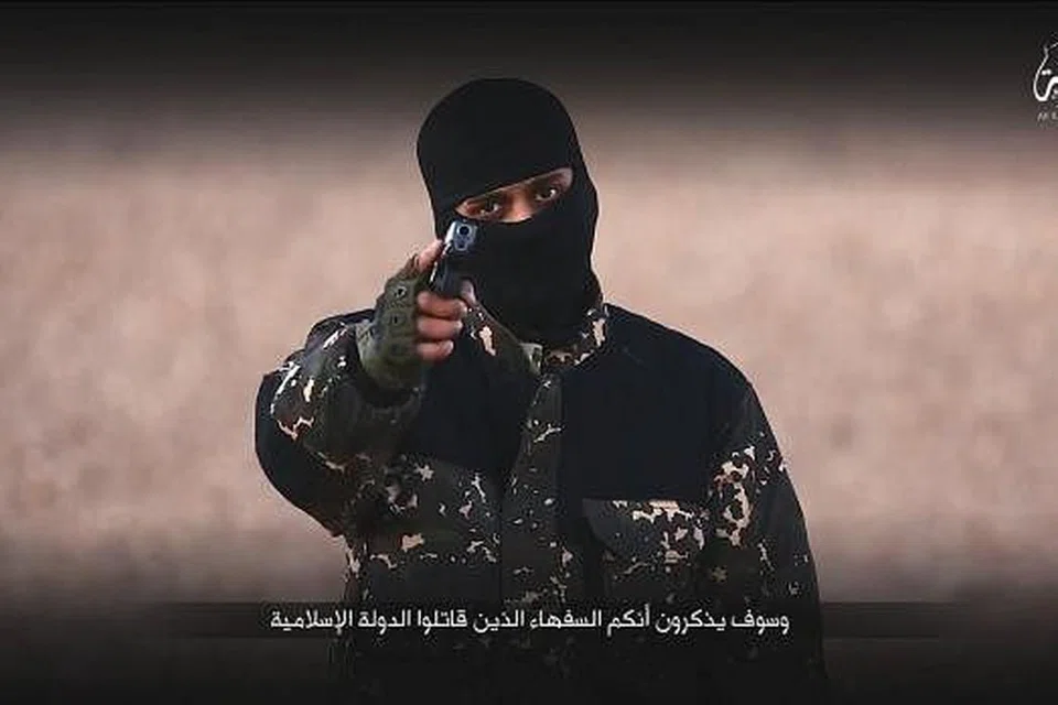 Seorang militan bertopeng mengacukan pistol dalam video terbaru ISIS yang turut memapar seorang budak lelaki berpakaian seragam tentera dan pembunuhan lima lelaki yang didakwa sebagai pengintip Britain. Gambar REUTERS 