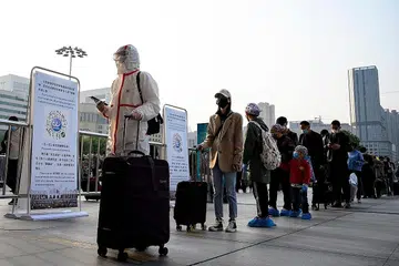 MAHU KELUAR WUHAN: Penduduk memakai pelitup sambil beratur di Stesen Kereta Api Hankou di Wuhan untuk meninggalkan ibu kota wilayah Hubei itu setelah perintah sekatan ketat ditarik balik Rabu lalu. - Foto AFP 