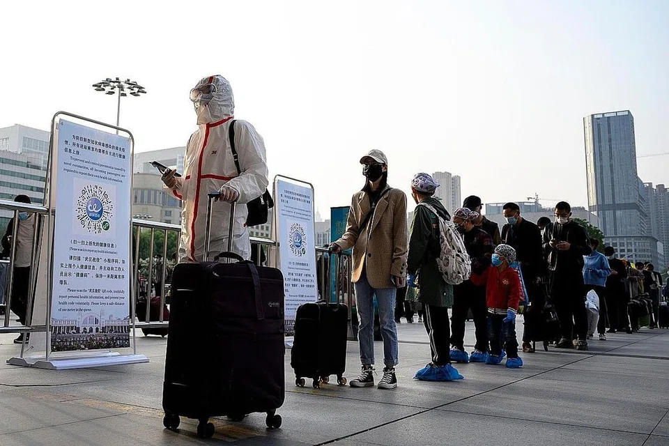 MAHU KELUAR WUHAN: Penduduk memakai pelitup sambil beratur di Stesen Kereta Api Hankou di Wuhan untuk meninggalkan ibu kota wilayah Hubei itu setelah perintah sekatan ketat ditarik balik Rabu lalu. - Foto AFP 