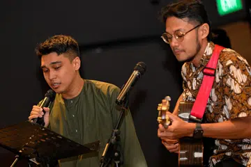 Encik Muhammad Syafiq Azman (kanan), antara Sahabat Sastera yang dilantik pada 2024, dan Sahabat Sastera ‘senior’, Encik Muhammad Ilyia Kamsani, mempersembahkan lagu ‘Ilham Pujangga’, yang dipopularkan oleh penyanyi Ismail Haron, di majlis pelantikan Sahabat Sastera 2024 di Wisma Geylang Serai pada 9 Jun. 