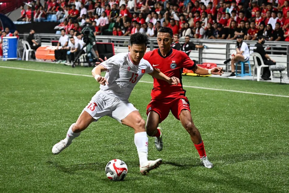 Pemain sayap Singa, Faris Ramli, cuba merampas bola daripada pemain pertahanan Vietnam, Ho Tan Tai, semasa pertarungan pertama di Stadium Jalan Besar pada 26 Disember.