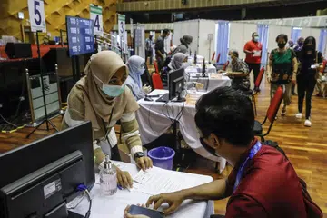 MAHU DIBERI VAKSIN: Orang ramai beratur di pusat vaksinasi di Shah Alam untuk mendapatkan vaksin Covid-19 mereka. Selangor mencatatkan kes harian tinggi yang memburukkan keadaan Covid-19 di Malaysia dan 'menjejas' negeri lain di Malaysia yang tidak mempunyai kes jangkitan yang tinggi. - Foto EPA-EFE 