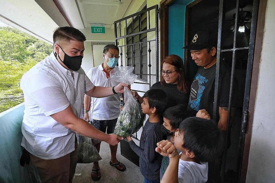 BERBESAR HATI: Cik Noorhafizah dan suaminya, Encik Muhd Shahhiran Anuar, seorang drebar, menerima agihan hasil tanaman program 'Gardens Give Back' daripada relawan semalam. - Foto BH oleh KEVIN LIM