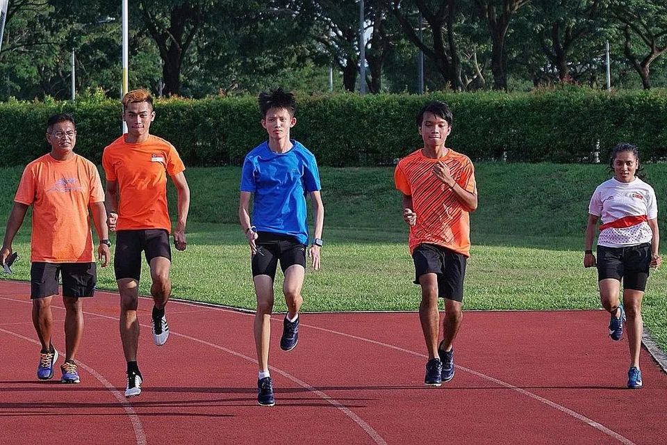 SASAR BERI YANG TERBAIK: Pasukan atletik para belia Singapura bagi Sukan Para Belia Asia 2021 terdiri daripada (dari dua dari kiri) Ariq, Maveric, Imran dan Nurhayati. Mereka diperhatikan oleh ketua jurulatih Hosni (paling kiri) ketika satu latihan di Trek Latihan Kallang baru-baru ini. - Foto BH oleh KHALID BABA