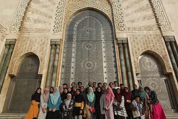 MASJID GAH!: Penulis (paling kiri) dan rakan-rakannya bergambar bersama di hadapan pintu Masjid Hassan Yang Kedua di Casablanca. - Foto ihsan SITI SYAHIRAH SHAHBUDIN