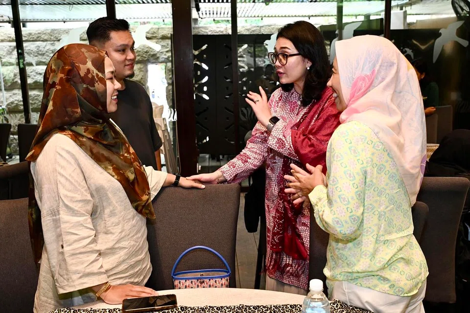 Anggota Parlimen (AP) GRC East Coast, Cik Hazlina Abdul Halim (dua dari kanan), serta Ketua Pegawai Eksekutif Persatuan Pemudi Islam Singapura (PPIS), Cik Aidaroyani Adam (kanan), beramah mesra bersama ibu bapa titipan semasa acara Hari Keluarga anjuran PPIS Oasis di Taman Haiwan Singapura pada 6 Disember