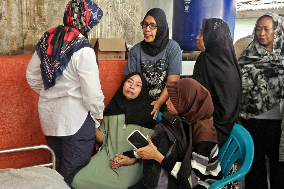 Cik Erlina, ibu kepada Allahyarham Affan Kurniawan, yang berusia 21 tahun, bersama anggota keluarga dan jiran tetangga.
