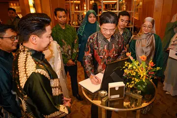 PERANAN PENTING 4PM: Timbalan Perdana Menteri, Encik Lawrence Wong (sedang menulis), menyentuh peranan penting yang dimainkan 4PM dalam pembangunan belia Melayu setempat. Beliau merupakan tetamu terhormat dalam majlis sambutan ulang tahun ke-75 4PM. Bersama beliau ialah Presiden 4PM, Encik Nassar Mohamad Zain (dua dari kiri) dan para relawan belia persatuan tersebut.
