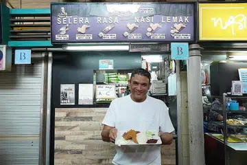 NASI LEMAK KEGEMARAN RAMAI: Semenjak pengiktirafan Unesco, Dr Abdul Malik Hassan telah menerima lebih ramai pelancong menjamu selera nasi lemak beliau di Pusat Penjaja Adam Road. - Foto BH oleh SYED MUHAMMAD FIRDAUS