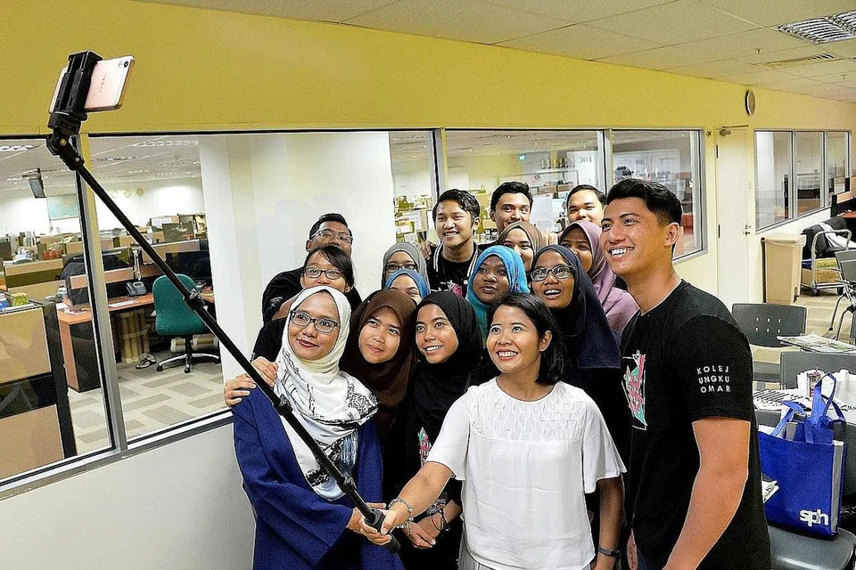 LAWATAN DARI SEBERANG TAMBAK: Sekumpulan pelajar daripada Kolej Ungku Omar, Universiti Kebangsaan Malaysia (UKM) bergambar bersama wartawan 'Berita Harian' semasa melawat bilik berita akhbar ini untuk mempelajari tentang industri media di Singapura, khususnya media Melayu. - Foto M.O. SALLEH
