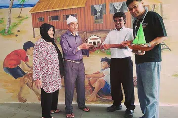 ISI MASA DENGAN KEGIATAN BERMANFAAT: Haji Abdul Rahman Kamarudin (berkopiah), yang mahir dalam kraf tangan seperti menghasilkan model rumah kampung, bersama isterinya, Hajah Kamsiah Abu Hassan, berbual mesra dengan Encik Adhar Jaafar (kanan) dan Encik Jamaludin Mohd Ibrahim (dua dari kanan). - Foto BM oleh SAINI SALLEH