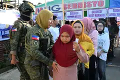 Anggota tentera memeriksa pengundi sebelum mereka memasuki sebuah pusat mengundi di Bandar Marawi, Mindanao, selatan Filipina, pada 14 September. Kira-kira 2.4 juta pengundi berdaftar mengundi untuk memilih 80 anggota Parlimen pertama Wilayah Autonomi Bangsamoro di Mindanao Muslim (BARMM), beberapa jam selepas tiga orang ditembak mati dan 15 lagi cedera dalam keganasan di luar sebuah pusat mengundi di Cotabato.