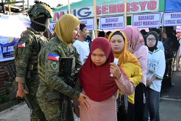 Anggota tentera memeriksa pengundi sebelum mereka memasuki sebuah pusat mengundi di Bandar Marawi, Mindanao, selatan Filipina, pada 14 September. Kira-kira 2.4 juta pengundi berdaftar mengundi untuk memilih 80 anggota Parlimen pertama Wilayah Autonomi Bangsamoro di Mindanao Muslim (BARMM), beberapa jam selepas tiga orang ditembak mati dan 15 lagi cedera dalam keganasan di luar sebuah pusat mengundi di Cotabato.