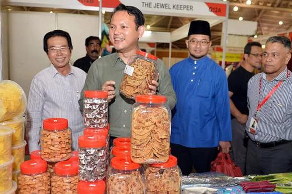 GALAK NIAGA: Anggota Parlimen (AP) GRC Chua Chu Kang, Encik Zaqy Mohamad (tiga dari kanan), bersama Pengarah Urusan MegaXpress International, Encik Hamzah Haji Abdullah (paling kiri); Pengerusi Masjid AlKhair, Encik Rashid Ramli (baju biru); dan Naib Pengerusinya, Encik Abdul Wahab (kanan) bertemu peniaga di Pameran Mega Wedding & Lifestyle and Exotica Indonesia anjuran MegaXpress di Singapore Expo semalam. - Foto M.O. SALLEH