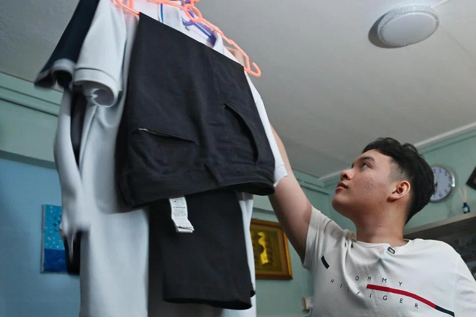 Satria mengambil seragam sekolahnya yang digantung dari siling di ruang tamu rumahnya. Setiap hari, ibunya, Cik Sukmawati akan membantu menggosok dan kemudian menggantung semua seragam kerja dan sekolah suami dan anak-anaknya di siling ruang tamu mereka.