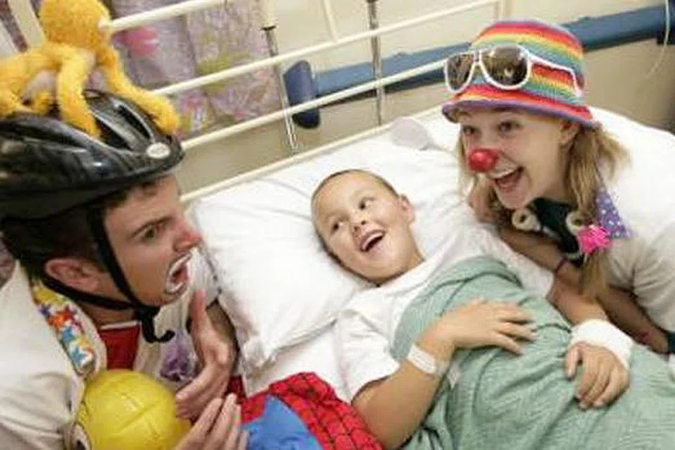 TIDAK LAGI MEMBOSANKAN: Seorang pesakit kanak-kanak dari Ireland ini pastinya tidak berasa bosan kerana kehadiran kededua doktor badut ini mengurangkan rasa tertekan di hospital. 