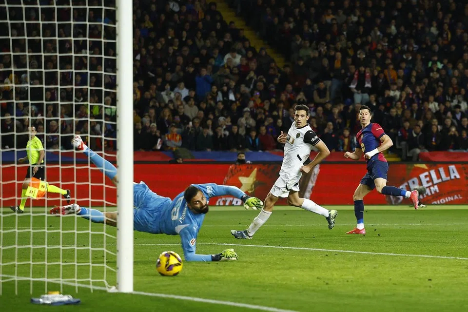 Penyerang Barcelona, Robert Lewandowski (paling kanan), berjaya menewaskan penjaga gawang Valencia, Giorgi Mamardashvili untuk gol keenam Barcelona. 
