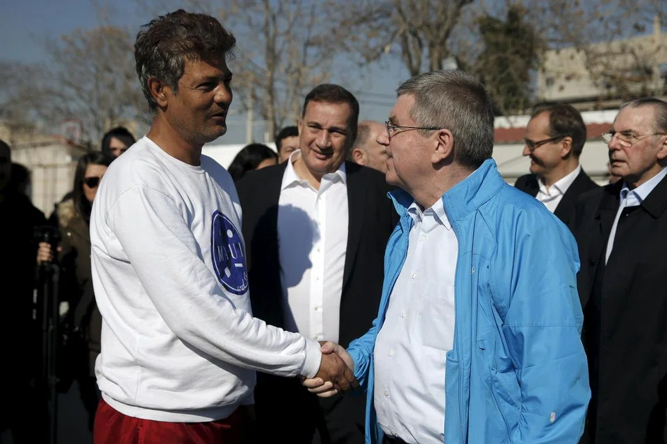 SUMBER INSPIRASI: Presiden Jawatankuasa Olimpik Antarabangsa (IOC), Thomas Bach (berjaket biru), menyapa seorang pelarian semasa melawat Kem Pelarian Eleonas di Athens, Greece, Januari lalu. - Foto REUTERS