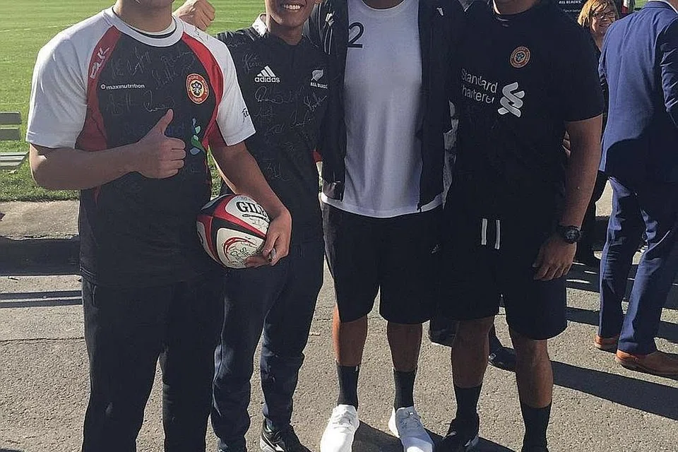 KENANGAN MANIS: (Dari kiri) Ng dan Solihin sempat bergambar dengan bintang All Blacks, Julian Savea. Di kanan sekali ialah pegawai SRU, Zaki Mahmood, yang menemani dua pemain muda itu dalam lawatan ke New Zealand ini. - Foto SRU