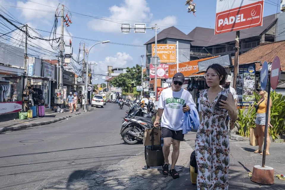 Pelancong bersiar-siar di kawasan beli-belah Seminyak, Bali, pada 26 Julai 2024.