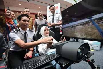 Menteri Negara (Penerangan dan Pembangunan Digital merangkap Kesihatan), Cik Rahayu Mahzam, yang juga Anggota Parlimen (AP) GRC Jurong mencuba simulasi penerbangan Singapore Airlines di acara Raikan Ilmu @Heartlands di Jurong Point pada 21 Julai.