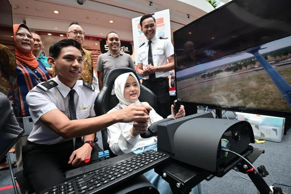 Menteri Negara (Penerangan dan Pembangunan Digital merangkap Kesihatan), Cik Rahayu Mahzam, yang juga Anggota Parlimen (AP) GRC Jurong mencuba simulasi penerbangan Singapore Airlines di acara Raikan Ilmu @Heartlands di Jurong Point pada 21 Julai.