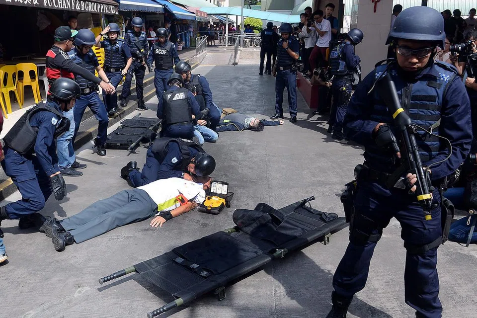 BERJAYA TANGANI SERANGAN 'PENGGANAS': Pegawai SCDF bertindak pantas dalam memberi pertolongan kecemasan kepada mangsa setelah polis daripada Pasukan Tindakan Kecemasan berjaya menawan pengganas dalam satu aksi senario yang mendebarkan. - Foto TAUFIK A. KADER