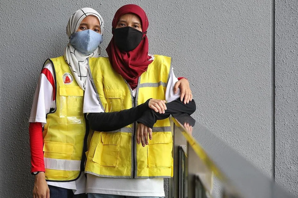 TABUR BAKTI: Putri Nor Atiqah dan ibunya Cik Siti Ashikin Hussin menjadi relawan Duta Jarak Selamat yang bergerak di kawasan Tampines seminggu sekali bagi memastikan orang ramai mematuhi peraturan pemutus litar dan mengamalkan jarak selamat. - Foto BH oleh JOEL CHAN YONG ZHI