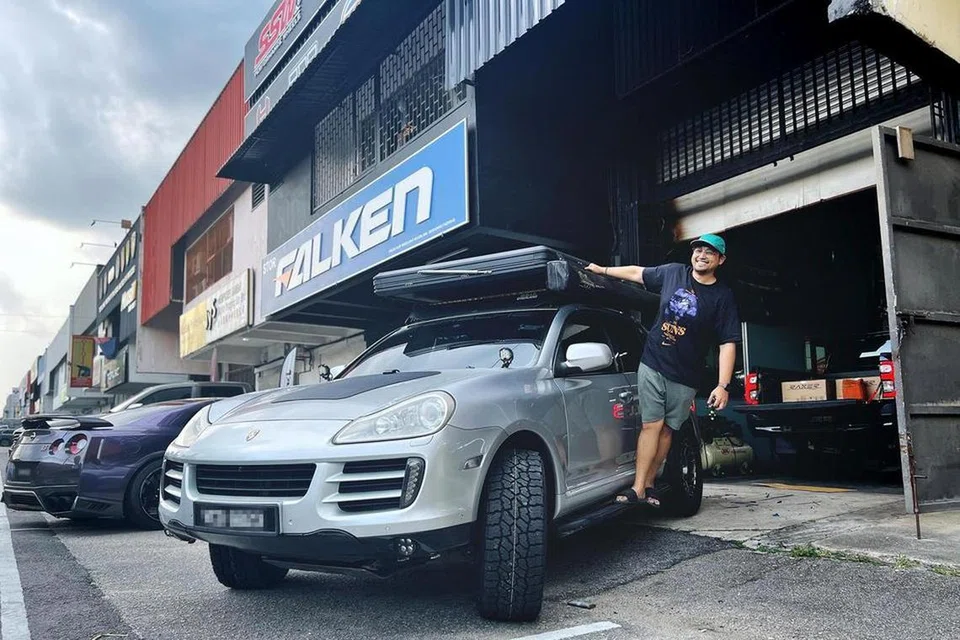 Usahawan e-dagang Singapura, Encik Iylia Kwan, bergambar bersama SUV Porsche Cayenne 2009 miliknya yang berdaftar di Malaysia. Ia dibeli secara terpakai pada harga RM50,000 (S$15,000) pada 2022.
