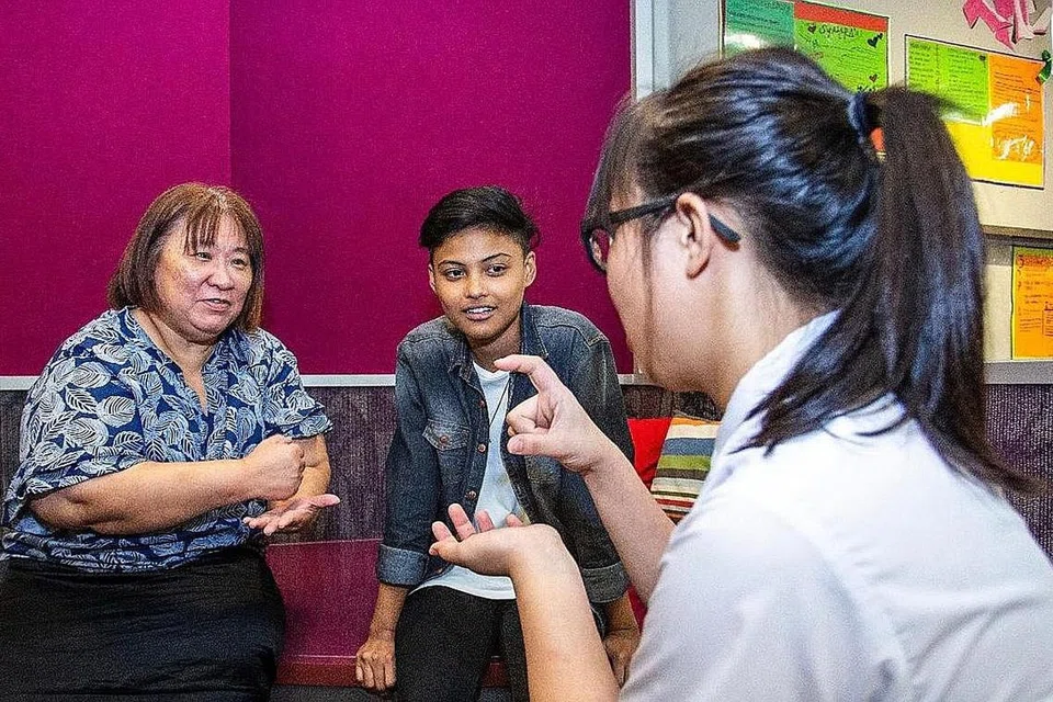DEKATI BELIA: Cik Ng (kiri) berinteraksi bersama kededua penerima anugerah, Syawalliah (tengah), yang sudah keluar daripada Rumah Budak Perempuan, dan Reina (bukan nama sebenar) yang masih ditempatkan di rumah tersebut. - Foto MSF
