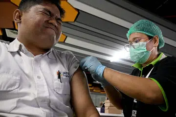 TIDAK LAGI PERCUMA: Seorang lelaki menerima vaksin penggalak koronavirus Inavac Covid-19 untuk pekerja lapangan terbang di Lapangan Terbang Ngurah Rai dekat Denpasar di pulau peranginan Bali pada 29 Disember sedang Ketua Perkhidmatan Kesihatan wilayah Jakarta, Cik Ani Ruspitawati, berkata vaksin Covid-19 berbayar akan dilaksanakan mulai 1 Januari 2024.