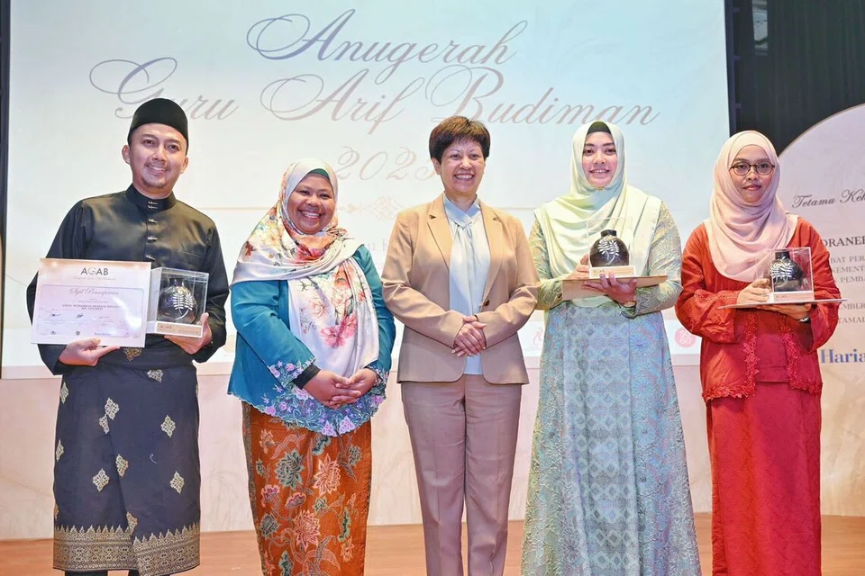 Menteri di Pejabat Perdana Menteri merangkap Menteri Kedua (Kewangan dan Pembangunan Negara), Cik Indranee Rajah (tengah), dan  Pengerusi Bersama Jawatankuasa Penganjur AGAB 2025, Dr Roszalina Rawi (dua dari kiri), bersama Penerima Anugerah Guru Arif Budiman (dari kiri) Encik Muhammad Mukhlis Dzulfitri Dzulkifli, Cik Filzatul Azreen Gazali dan Cik Siti Suhana Alias.
