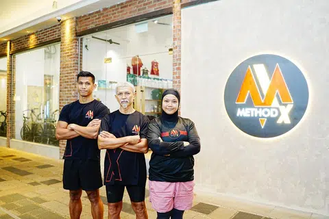 Dua adik-beradik itu, Encik Hafiz (kiri) dan Cik Norliyana (kanan) telah membuka gimnasium kecergasan di Gopeng Street sejak 2023. Bapanya, Encik Jumahat (tengah) berasa bangga dengan pencapaian anaknya ini.