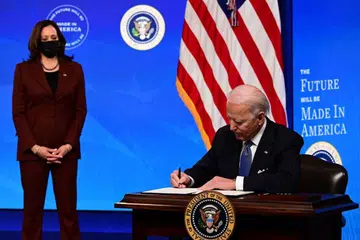 UTAMA BUATAN AMERIKA: Presiden Joe Biden, dengan disaksikan Naib Presiden Kamala Harris, menandatangani perintah eksekutif yang memberi penekanan pada pengeluaran nasional dan menyelamatkan pekerjaan industri tempatan. - Foto AFP