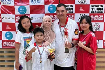 JUARA: Rudy Hesty (dua dari kanan), pemain Subbuteo dari Singapura meraih kemenangan ‘treble’ semasa Piala Asia Bola Sepak Meja, di Kashiwa, Tokyo pada awal Julai lalu bergambar bersama isterinya Cik Norita Mohd Noh (bertudung), anak sulung Cik Erin Nashira (paling kanan), Ezlyn Naresha (paling kiri) dan anak bongsunya Edin Reyza (kedua dari kiri).
