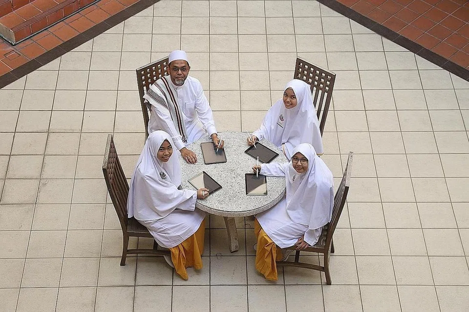 MENGASAH KEMAHIRAN: Mudir Madrasah, Ustaz Syed Mustafa Alsagoff, bersama pelajar (dari kiri) Nurhana Rehan, Sofiyyah Mohd Amirullah dan Nurwada'ah Mohamed di perkarangan madrasah. Menurut para pelajar, dengan menggunakan iPad, mereka dapat mengasah kemahiran dalam seni seperti melukis dan juga membolehkan mereka berfikiran secara kritikal dan terbuka.