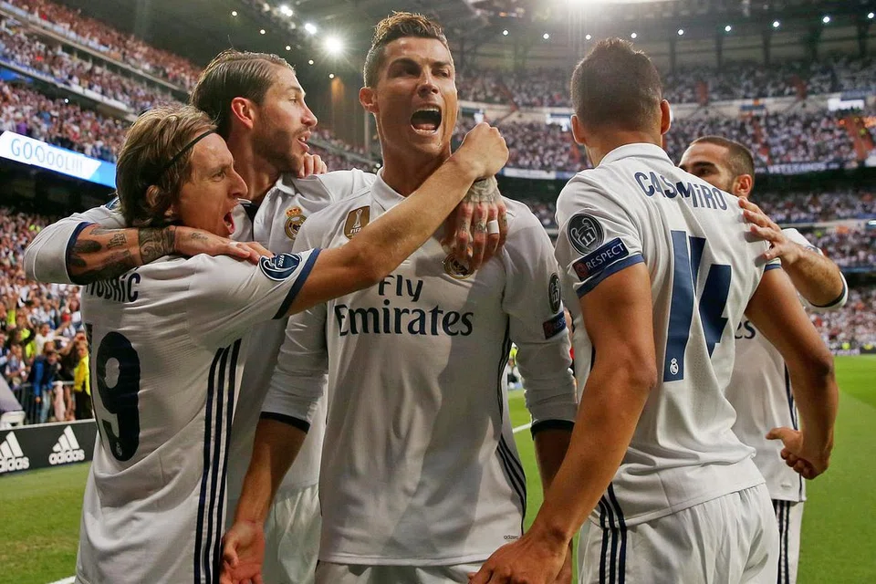 WIRA DIKERUMUNI: Bintang Real Madrid, Cristiano Ronaldo (tengah), meraikan golnya bersama rakan pasukan semasa kemenangan 3-0 ke atas Atletico Madrid. - Foto REUTERS