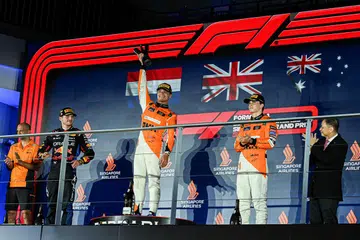 Pemandu McLaren, Lando Norris (tengah), meraikan kemenangannya dalam perlumbaan Grand Prix Singapura Formula Satu pada 22 September. 
