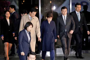 BEREDAR: Cik Park Geun-hye (gambar atas, tengah) beredar keluar dari pejabat pendakwa raya Korea Selatan semalam setelah disoal siasat berhubung skandal rasuah. - Foto AFP