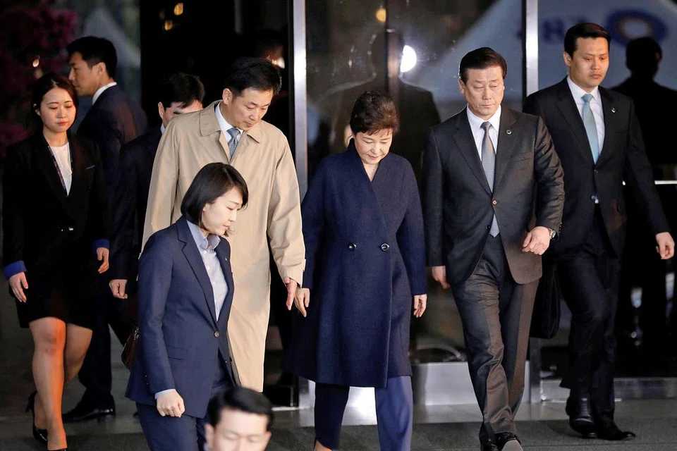 BEREDAR: Cik Park Geun-hye (gambar atas, tengah) beredar keluar dari pejabat pendakwa raya Korea Selatan semalam setelah disoal siasat berhubung skandal rasuah. - Foto AFP